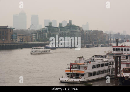 Londra, Regno Unito. Il 2 aprile 2014. Canary Wharf svanisce sotto una coltre di foschia atmosferica, come il Met Office previsioni smog gravi a Londra questa settimana a causa di una combinazione di inquinamento dell'aria, luce sud venti da est e da una tempesta sahariana che è la deposizione di fine polvere rossa nell'atmosfera. Defra giornaliera dell indice di qualità dell'aria consigliata quelle con cattive condizioni di salute o del polmone Condizioni da evitare strenuo esercizio outdoor e asmatici dovrebbero assicurarsi che essi hanno il loro inalatore a mano. Credito: Patricia Phillips/Alamy Live News Foto Stock