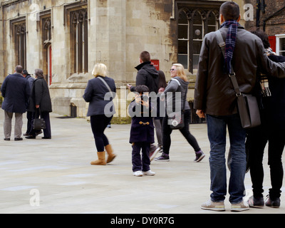 Un giovane ragazzo prende una fotografia dei suoi genitori dei passanti nei pressi della cattedrale di York, UK, una popolare destinazione turistica. Foto Stock