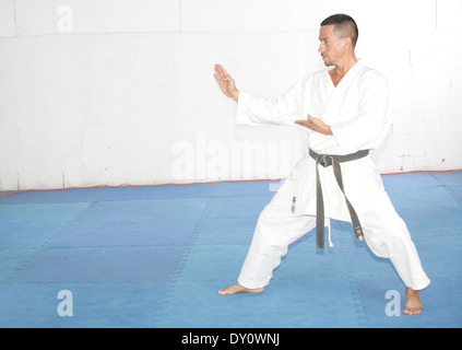 La cintura nera uomo in kimono durante il training karate kata esercizi Foto Stock