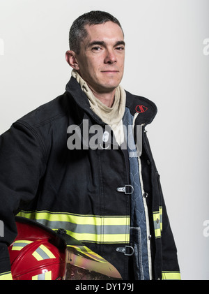 Firefighter maschio in estinzione strutturali uniforme con apparato di respirazione e ax Foto Stock