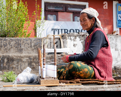 Anziana donna Gurung tessitura di una sciarpa tradizionale nel villaggio di Dhampus, Nepal Foto Stock