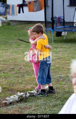Fratello aiutando la sorella equilibrio sul log in back yard età di 6 e 8. Zawady Polonia centrale Foto Stock