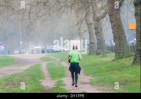 Londra, Regno Unito. 03 apr 2014. L'inquinamento atmosferico è elevato a Londra a causa di veicolo e le emissioni industriali la miscelazione con il deserto di sabbia per creare un simile di smog di nebbia. Questo non si ferma per i ciclisti e per chi ama fare jogging da esercitare in essa attorno a Clapham Common durante le ore di punta. Clapham, Londra, UK, 03 aprile 2014. Credito: Guy Bell/Alamy Live News Foto Stock