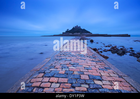 La strada rialzata che conduce a Saint Michaels Mount in Cornwall Inghilterra durante la bassa marea, fotografata nel blu ora all'alba Foto Stock