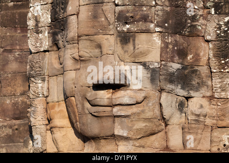 Sorridente faccia di pietra nel tempio Bayon in Angkor vicino a Siem Reap, Cambogia Foto Stock