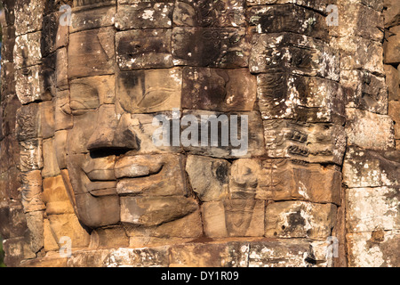 Sorridente faccia di pietra nel tempio Bayon in Angkor vicino a Siem Reap, Cambogia Foto Stock