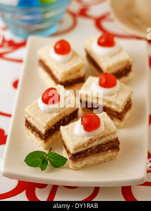 Le torte a base di pan di spagna con cioccolato e ciliegie. Ricetta disponibile. Foto Stock