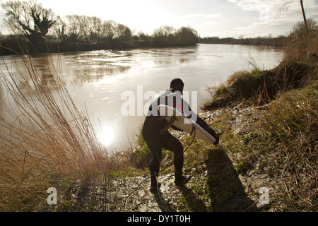 Testa di surfisti di cavalcare la Severn alesaggio sul fiume Severn a Minsterworth Gloucestershire England Regno Unito Foto Stock