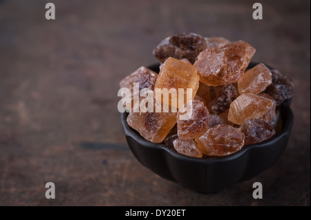 Grande marrone zucchero candito su uno sfondo di legno Foto Stock