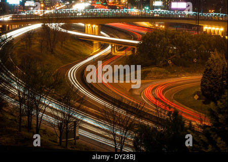 Fari anteriori e luci di posizione posteriori vernice corse illuminato in questa scena notturna di Atlanta, Georgia il traffico. Stati Uniti d'America. Foto Stock