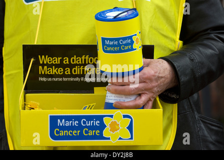 La donna la raccolta di fondi per le borse Marie Curie per la cura del cancro di carità, High Street, Alton, HAMPSHIRE, Regno Unito. Foto Stock