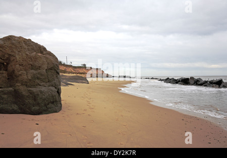 Una vista della spiaggia con scogliere di erosione e rock corazza mare difese a Happisburgh, Norfolk, Inghilterra, Regno Unito. Foto Stock
