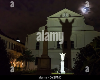 La luna piena sorge su di Sant'Antonio giardino con un'ombra dalla statua di Gesù nel Quartiere Francese di New Orleans, LA Foto Stock