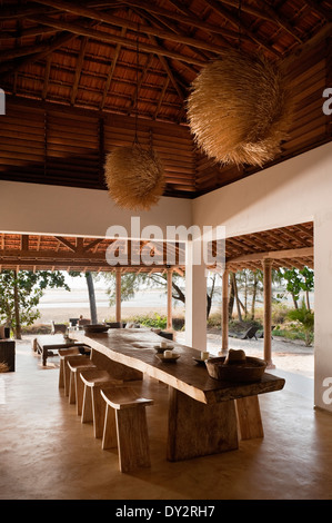 Sala da pranzo con travi interni con paralumi strutturata in beach house retreat nello stato indiano di Goa Foto Stock