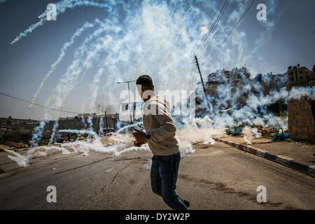 Ramallah, Territori palestinesi. 4 apr, 2014. Gas lacrimogeni riempie l'aria alla prigione di Ofer dimostrazione. 17 palestinesi feriti durante una protesta Israele per la ritrazione dell'ultimo rilascio dei prigionieri accordo. Decine di feriti e più ha sofferto gravi di inalazione di gas. Fotografo palestinese, sostenuto due feriti, nello stomaco e faccia dall'esercito d'Israele. Credito: Hamde Abu Rahma/NurPhoto/ZUMAPRESS.com/Alamy Live News Foto Stock