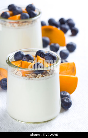 Due bicchieri di yogurt con granola e bacche Foto Stock