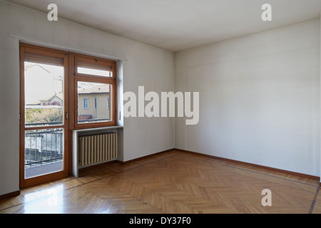 Stanza vuota con pavimento in legno e sporco e pareti di colore bianco Foto Stock