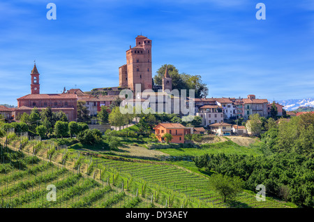Piccola cittadina con il castello medievale e il verde dei vigneti in discesa in primavera in Piemonte, Italia settentrionale. Foto Stock