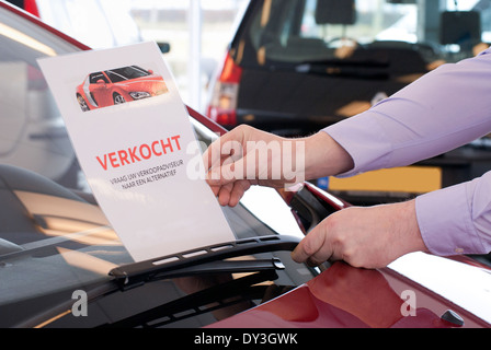 Venditore auto mette a segno venduto sotto il tergicristallo di un auto che è venduto Foto Stock