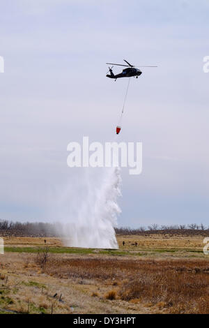 Commerce City, Colorado, Stati Uniti d'America - 5 aprile 2014. I membri di Boulder dei Vigili del fuoco e il Colorado National Guard 2° Battaglione, 135Supporto Generale di Brigata Aerea basata al di fuori del Buckley Air Force Base in Aurora, Colorado praticare la loro comunicazione e caduta della benna tecniche al Rocky Mountain Arsenal National Wildlife Refuge in preparazione per Colorado di incendio imminente stagione. Questo è il primo anno che i vigili del fuoco sulla terra sono in grado di comunicare con quelli in aria per coordinare la lotta antincendio sforzo. Credit: Ed Endicott/Alamy Live News Foto Stock