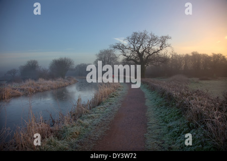 Sunrise su un gelido gennaio mattina presto sul Grand Canal Occidentali, Burlescombe, Devon con un lone runner - pareggiatore all'alba Foto Stock