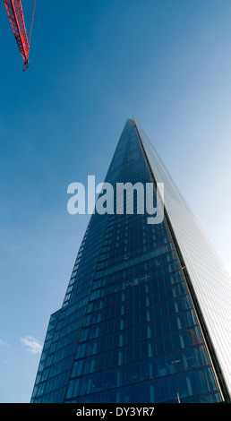 Una gru rosso da un edificio adiacente sito e la costruzione di Shard London Bridge trimestre Inghilterra UK KATHY DEWITT Foto Stock