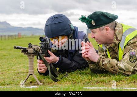 Magilligan, Irlanda del Nord. 5 apr 2014 - un elemento femmina della pressa riceve istruzioni per l'uso di una SA80 fucile da assalto Foto Stock