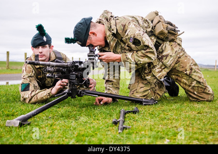 Un soldato dal 2 Batt Royal Irish Regiment allinea una macchina per usi generici pistola (GPMG) utilizzando la sua vista adjustible Foto Stock