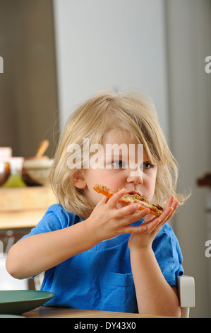 Ragazzo giovane gode di un trancio di pizza Foto Stock