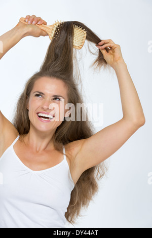 Felice giovane donna pettinare capelli Foto Stock