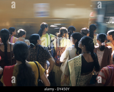 India Mumbai 6 miliardi di pendolari in viaggio i treni locali della stazione ferroviaria occidentale tra il centro città e suburbans quotidianamente le donne aspettare autobus speciale Foto Stock