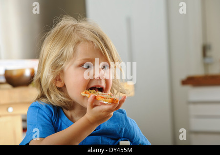 Ragazzo giovane gode di un trancio di pizza Foto Stock