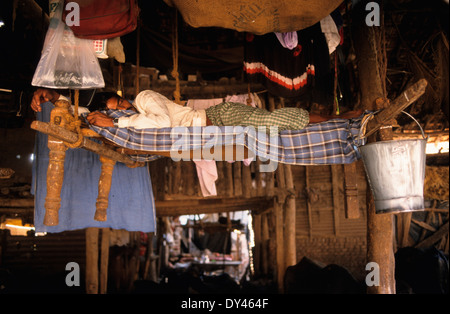 INDIA Mumbai Bombay, stabili con il bufalo d'acqua per la produzione di latte nella zona soggiorno nella zona suburbana di Andheri lattaio dormire dopo il lavoro Foto Stock