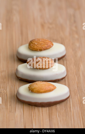 Tre cioccolati di lusso su una scheda di bambù. Foto Stock