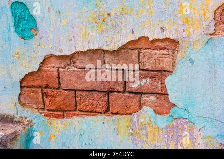 Colorfully intonaco dipinto chipping off di un muro di mattoni Foto Stock