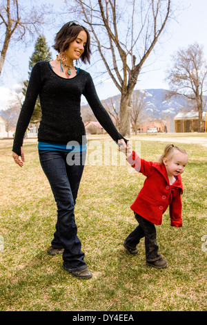 Giovane e bella madre giocando con gli adorabili, cute 16 mese Baby girl su parco giochi per bambini Foto Stock