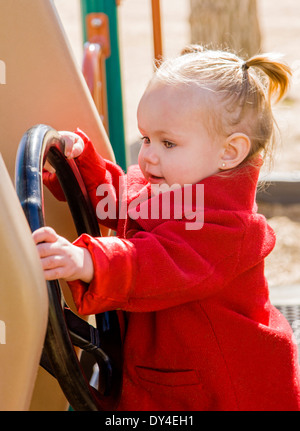 Adorabili, carino 16 mese bambina gioca su un parco giochi per bambini Foto Stock