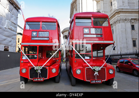 Due iconico autobus rossi ingaggiato per matrimonio parcheggiata fuori dalla cattedrale di St Paul, Londra, Inghilterra. Foto Stock