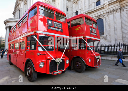 Due iconico autobus rossi ingaggiato per matrimonio parcheggiata fuori dalla cattedrale di St Paul, Londra, Inghilterra. Foto Stock