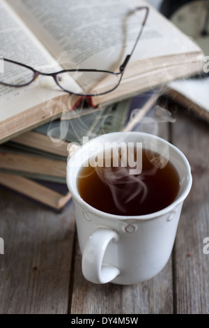 Pila di libri con bicchieri e tazze di tè. Messa a fuoco selettiva. Foto Stock