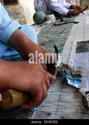 Peshawar. 7 apr, 2014. Operai craft tappeti fatti a mano in una fabbrica nella periferia di nord-ovest del Pakistan Peshawar il 7 aprile 2014. © Ahmad Sidique/Xinhua/Alamy Live News Foto Stock