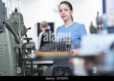 Ritratto di donna ingegnere tenendo un vassoio di drillbits Foto Stock