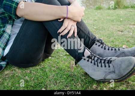 Vita scende, giovane donna seduta su erba Foto Stock