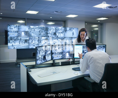Le guardie di sicurezza lavorando a schermi TVCC in sala di controllo