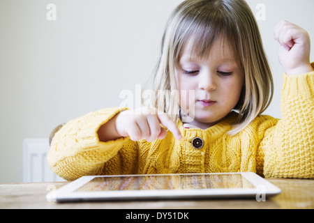 Giovane ragazza al tavolo della cucina con tavoletta digitale Foto Stock