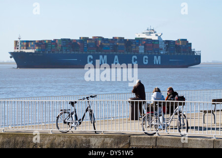 La gente guarda come la nave portacontainer CMA CGM Musca passa Brunsbuettel Foto Stock