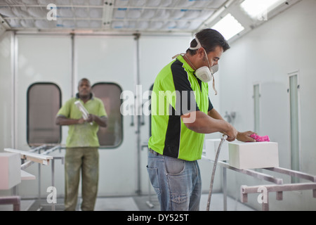 Uomo casella di spruzzatura in laboratorio di ebanisteria Foto Stock