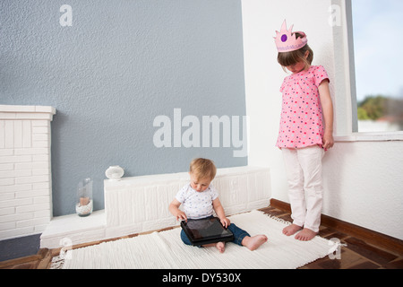 Ragazza a guardare oltre baby boy riproduzione digitale compressa Foto Stock