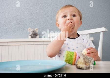 Baby boy mangiare cupcake Foto Stock