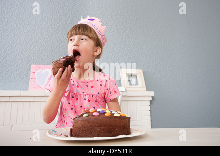 Ragazza di mangiare la sua torta di compleanno Foto Stock